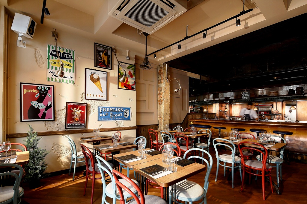 Picture of the colourful chairs and rustic tables inside The Study restaurant at Keong Saik Road